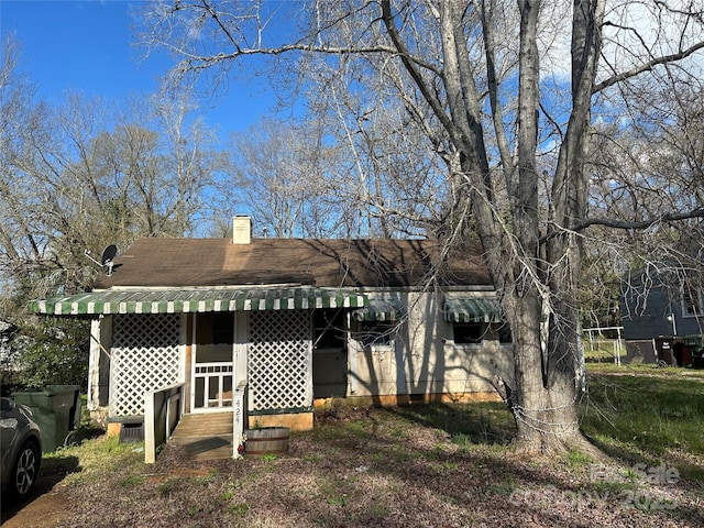 rear view of house featuring entry steps and a chimney