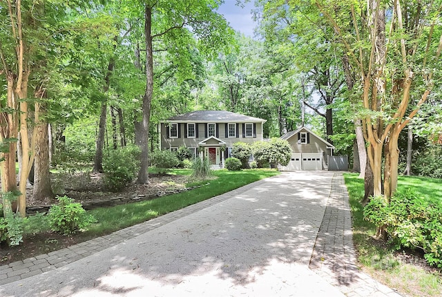 colonial home with a garage, an outbuilding, and concrete driveway