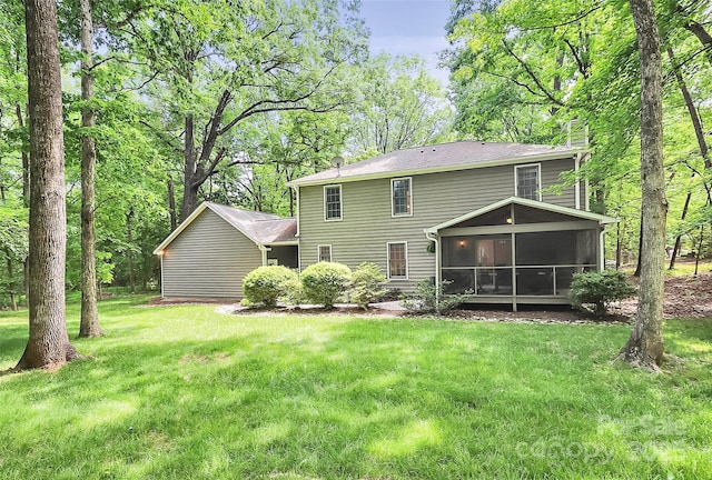 back of property featuring a lawn and a sunroom