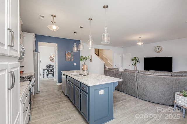 1512 Brooksland Pl, Waxhaw, NC 28173 - kitchen featuring a sink, appliances with stainless steel finishes, blue cabinets, white cabinetry, and light wood-style floors