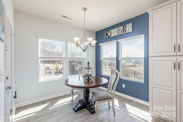 1512 Brooksland Pl, Waxhaw, NC 28173 - dining room featuring a chandelier, light wood finished floors, and baseboards