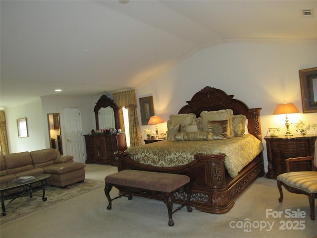 carpeted bedroom featuring lofted ceiling, ornamental molding, and visible vents
