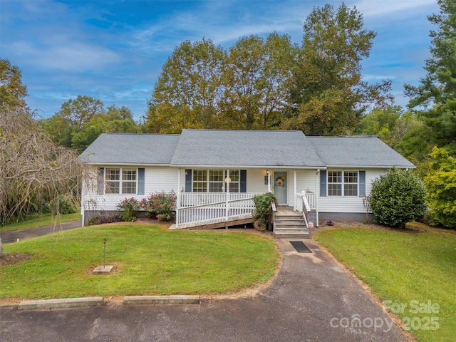 ranch-style house featuring covered porch and a front yard