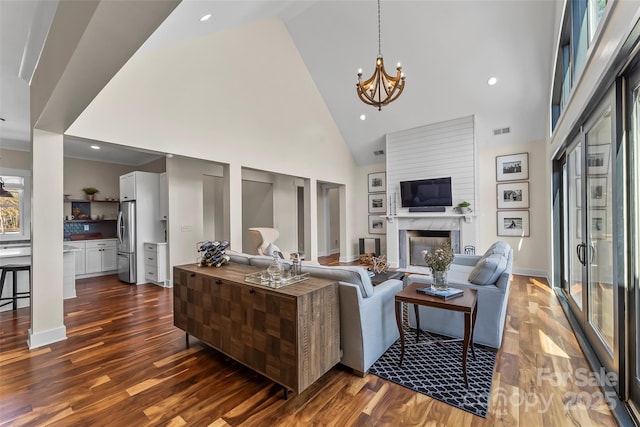 1289 Northview Dr, Morganton, NC 28655 - living room with visible vents, a fireplace, high vaulted ceiling, dark wood-style floors, and a notable chandelier