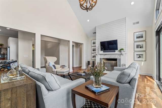 1289 Northview Dr, Morganton, NC 28655 - living room with a premium fireplace, high vaulted ceiling, recessed lighting, light wood-type flooring, and visible vents