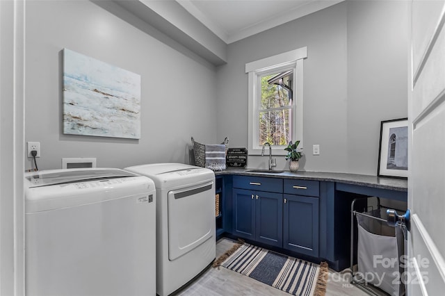1289 Northview Dr, Morganton, NC 28655 - clothes washing area featuring washing machine and dryer, cabinet space, a sink, light wood-style floors, and ornamental molding