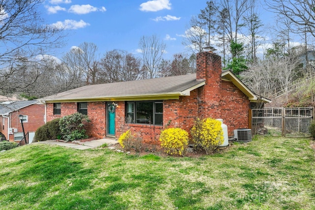 ranch-style home with brick siding, central AC unit, and a front lawn