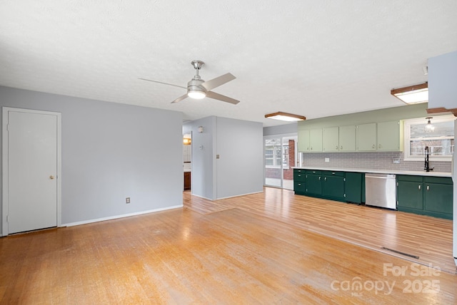 unfurnished living room with visible vents, light wood-style flooring, ceiling fan, and a sink