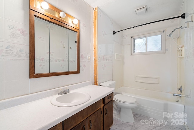 full bathroom featuring toilet, vanity, marble finish floor, visible vents, and shower / bath combination