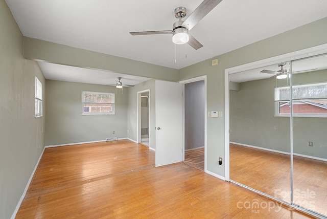 unfurnished bedroom with baseboards, ceiling fan, and light wood-style floors