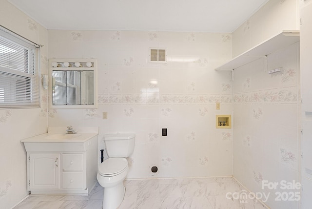 bathroom featuring tile walls, visible vents, marble finish floor, toilet, and vanity