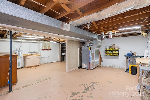 unfinished basement featuring heating unit and electric water heater