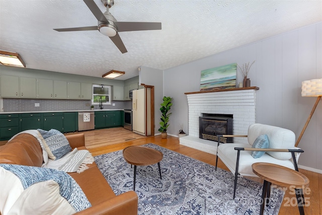 31 Vista Dr, Candler, NC 28715 - living area featuring light wood-type flooring, a ceiling fan, a fireplace, and a textured ceiling