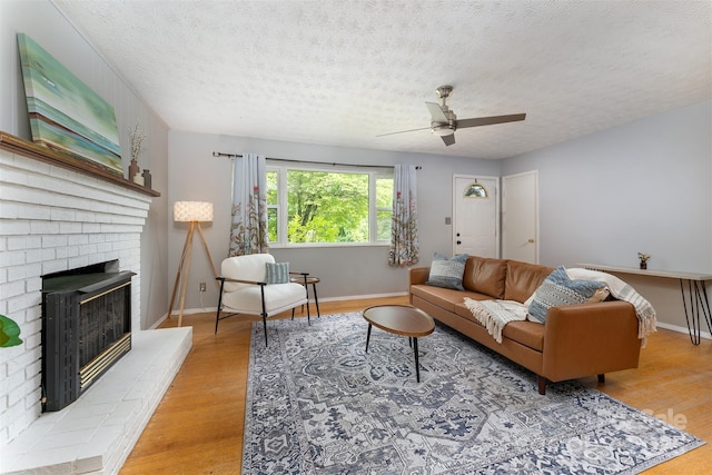 31 Vista Dr, Candler, NC 28715 - living room with a ceiling fan, wood finished floors, a textured ceiling, a fireplace, and baseboards