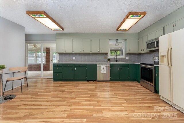 31 Vista Dr, Candler, NC 28715 - kitchen with appliances with stainless steel finishes, green cabinets, light countertops, light wood finished floors, and a textured ceiling