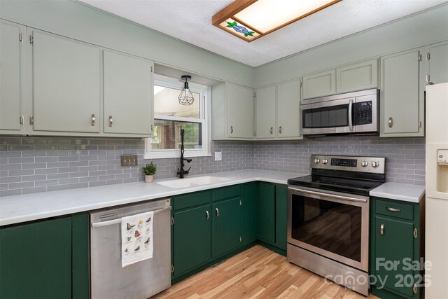 31 Vista Dr, Candler, NC 28715 - kitchen with stainless steel appliances, a sink, light wood finished floors, and backsplash