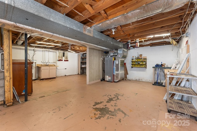31 Vista Dr, Candler, NC 28715 - unfinished below grade area with heating unit, water heater, and a sink
