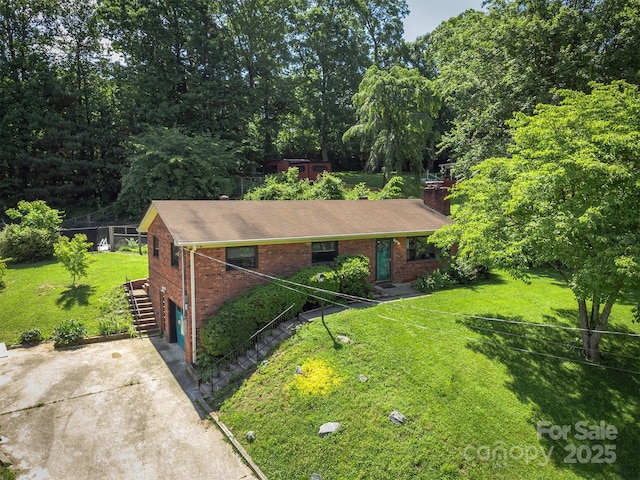 31 Vista Dr, Candler, NC 28715 - single story home with brick siding, a chimney, concrete driveway, stairs, and a front lawn
