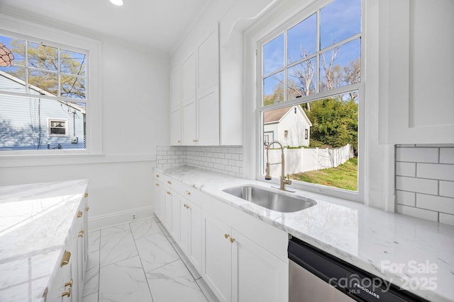 clothes washing area with baseboards, ornamental molding, recessed lighting, marble finish floor, and a sink
