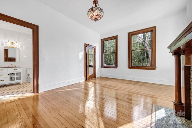 interior space featuring light wood-style flooring, baseboards, and ornamental molding
