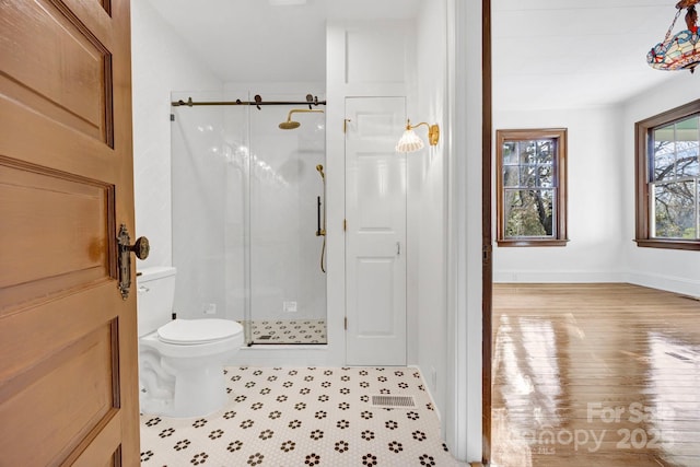 full bath featuring tile patterned flooring, a shower stall, toilet, and baseboards