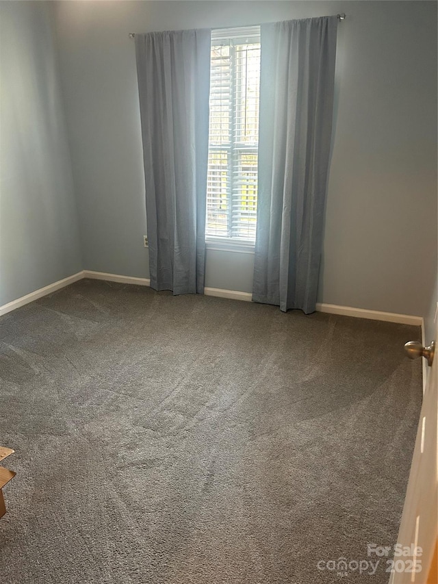 carpeted empty room featuring baseboards