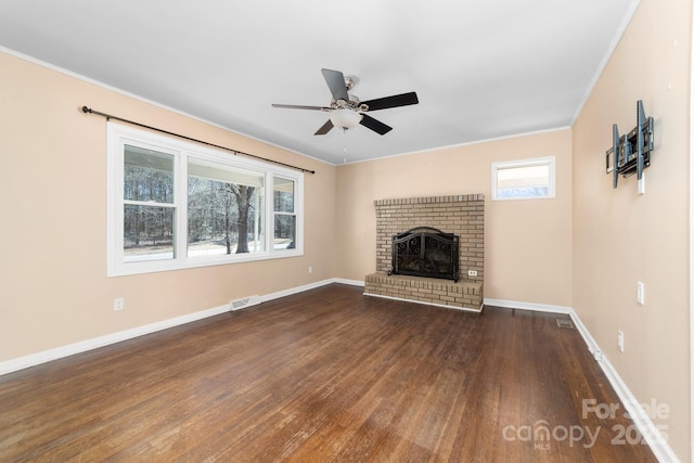 unfurnished living room featuring visible vents, dark wood finished floors, baseboards, a brick fireplace, and ceiling fan