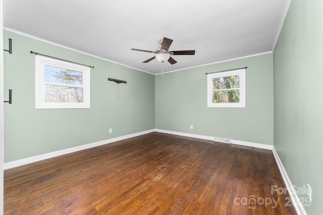 spare room featuring crown molding, a ceiling fan, baseboards, and dark wood-style flooring