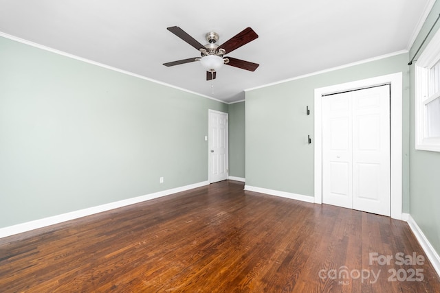 interior space with a closet, baseboards, dark wood-style floors, and crown molding