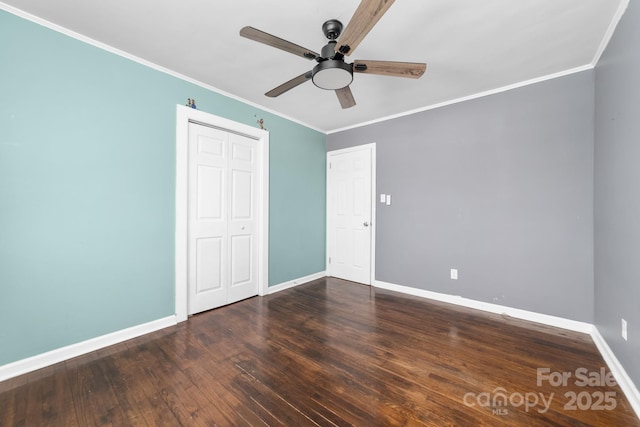 unfurnished bedroom featuring a closet, crown molding, baseboards, and hardwood / wood-style flooring