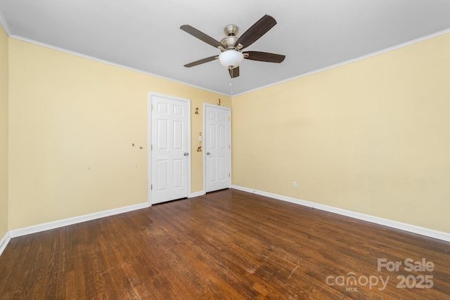 spare room with dark wood-type flooring, a ceiling fan, and crown molding