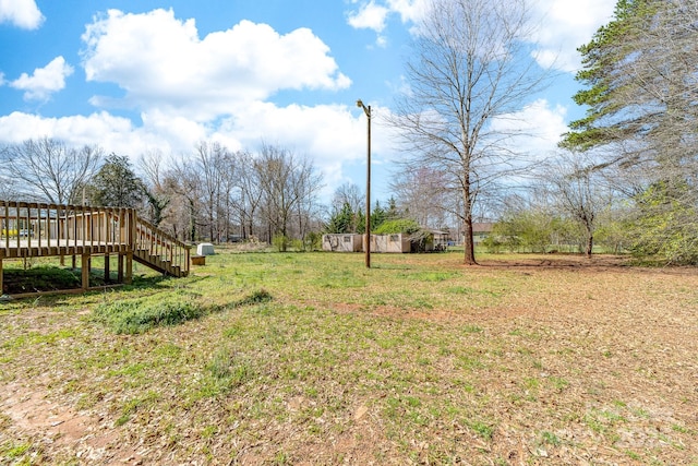 view of yard featuring stairs and a wooden deck