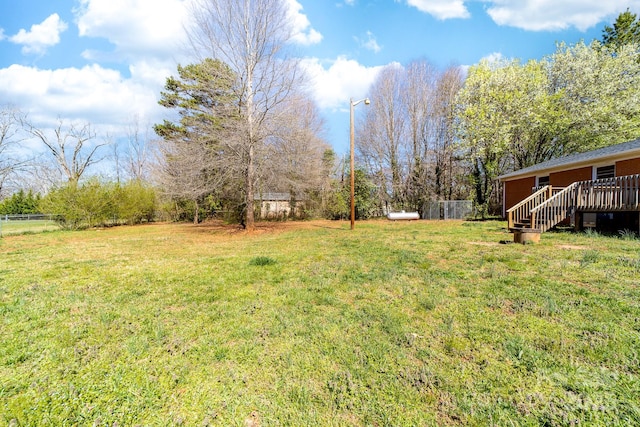 view of yard with a wooden deck and fence