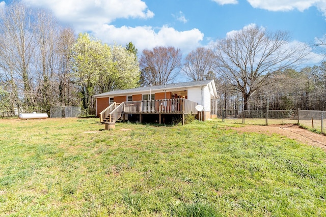 rear view of property with a deck, a lawn, and a fenced backyard