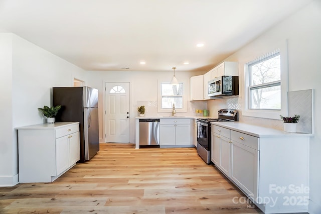 1116 Carolina Ave, Rock Hill, SC 29730 - kitchen with tasteful backsplash, stainless steel appliances, hanging light fixtures, a sink, and light wood finished floors