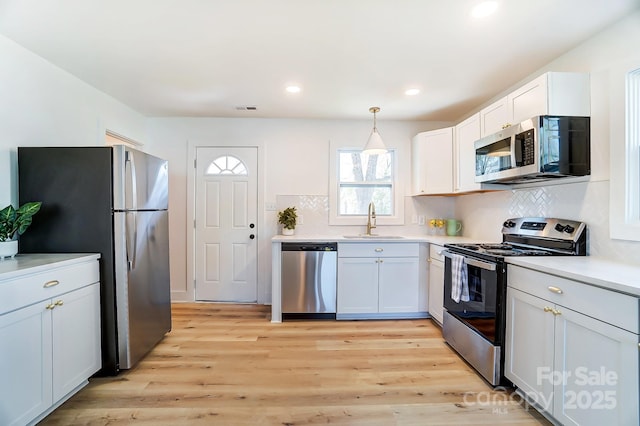1116 Carolina Ave, Rock Hill, SC 29730 - kitchen with a sink, light wood finished floors, tasteful backsplash, appliances with stainless steel finishes, and visible vents