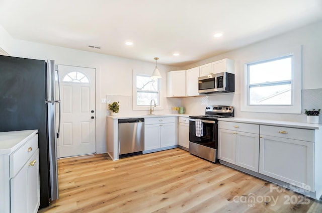 1116 Carolina Ave, Rock Hill, SC 29730 - kitchen with decorative backsplash, visible vents, stainless steel appliances, a sink, and light wood-type flooring