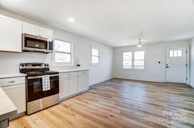 1116 Carolina Ave, Rock Hill, SC 29730 - kitchen featuring white cabinetry, light countertops, light wood-style flooring, stainless steel appliances, and a ceiling fan