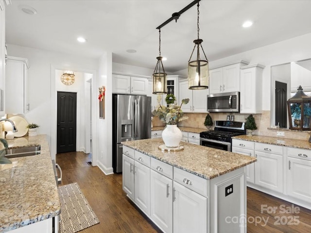 604 Wisteria Walk Way, Fort Mill, SC 29715 - kitchen featuring appliances with stainless steel finishes, a sink, white cabinets, decorative backsplash, and a center island