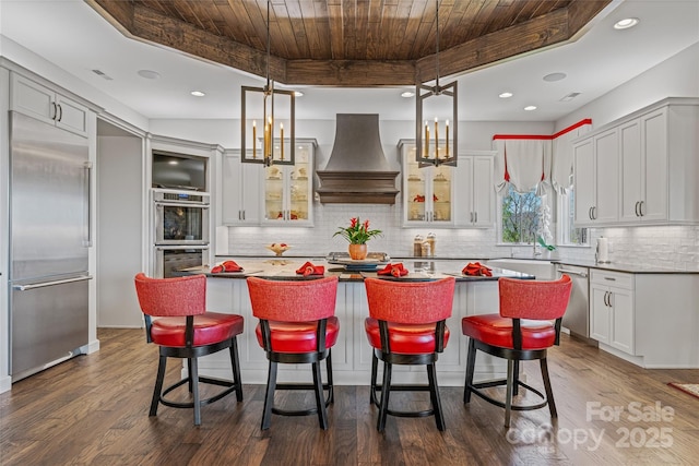 349 Stoneledge Trl, Arden, NC 28704 - kitchen with custom range hood, a tray ceiling, wooden ceiling, and stainless steel appliances