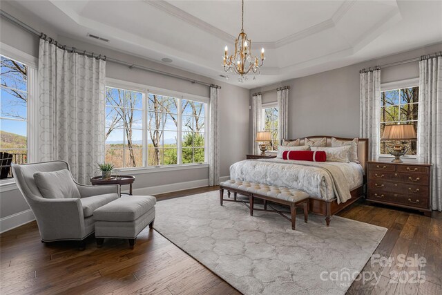 349 Stoneledge Trl, Arden, NC 28704 - bedroom featuring a tray ceiling, multiple windows, a notable chandelier, and dark wood finished floors