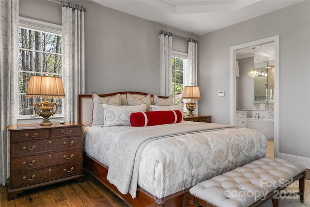 349 Stoneledge Trl, Arden, NC 28704 - bedroom featuring dark wood-style flooring, connected bathroom, and an inviting chandelier