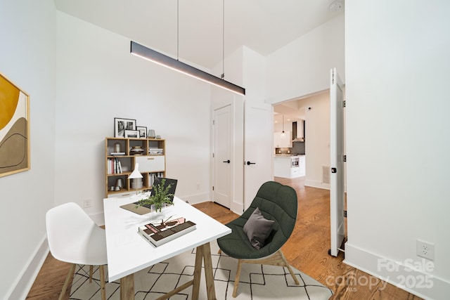 dining space with baseboards and wood finished floors