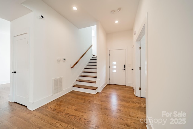 entrance foyer featuring stairs, visible vents, wood finished floors, and recessed lighting