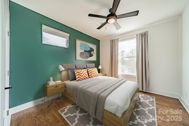 bedroom with baseboards, ceiling fan, and wood finished floors