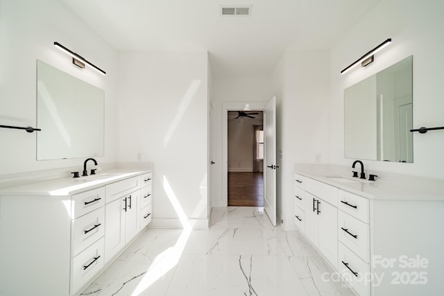 bathroom featuring a sink, marble finish floor, visible vents, and two vanities