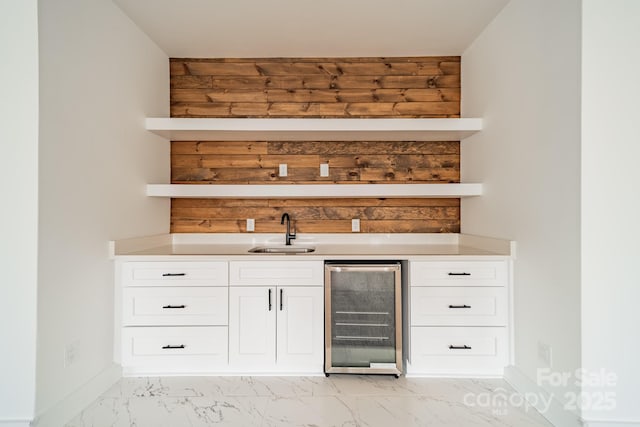 bar with wood walls, marble finish floor, wine cooler, a sink, and indoor wet bar