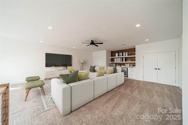 living room featuring carpet flooring, recessed lighting, built in features, and ceiling fan