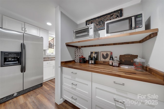 kitchen with open shelves, wood finished floors, wooden counters, stainless steel appliances, and white cabinets