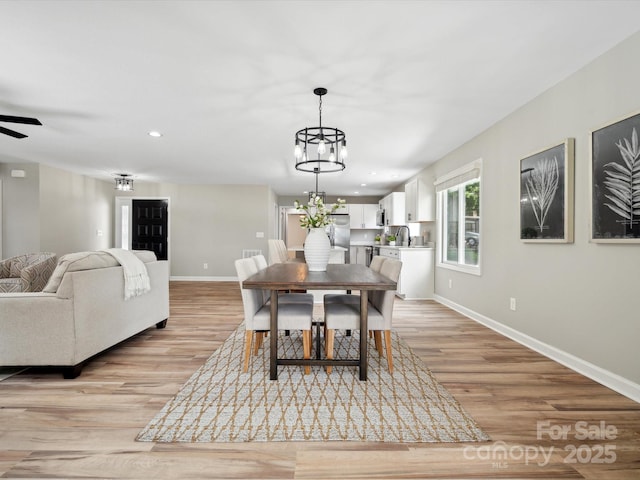 dining room with light wood-style flooring, baseboards, and recessed lighting
